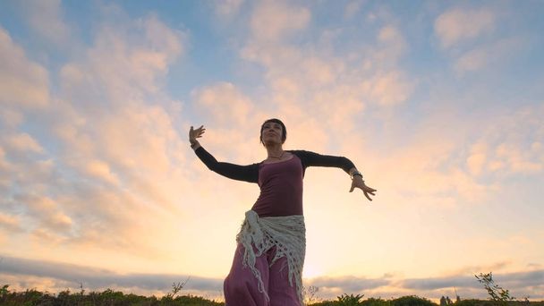 Happy female dance in the summer fields during beautiful sunset - Foto, Imagem