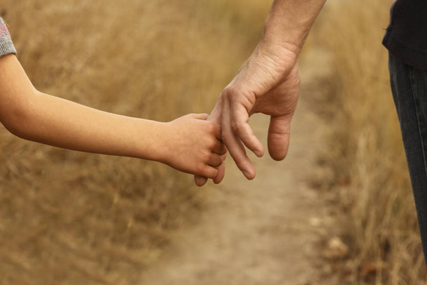 rodzic trzyma za rękę małe dziecko - Zdjęcie, obraz