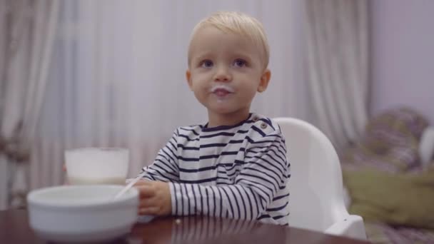 Cute infant eating. Happy baby eating porridge with spoon. - Felvétel, videó
