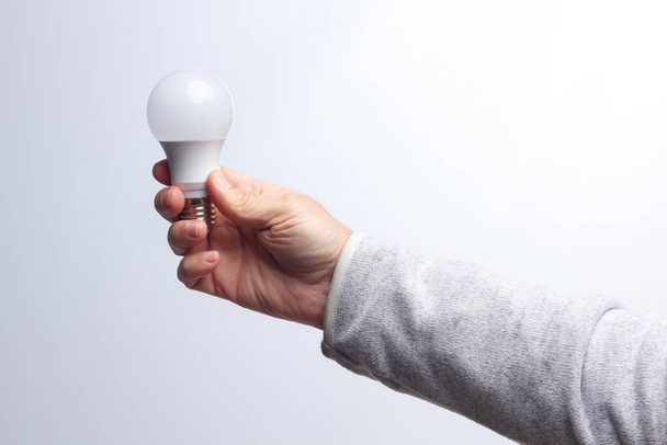 Energeticky úsporná žárovka v ruce dospělého - Fotografie, Obrázek