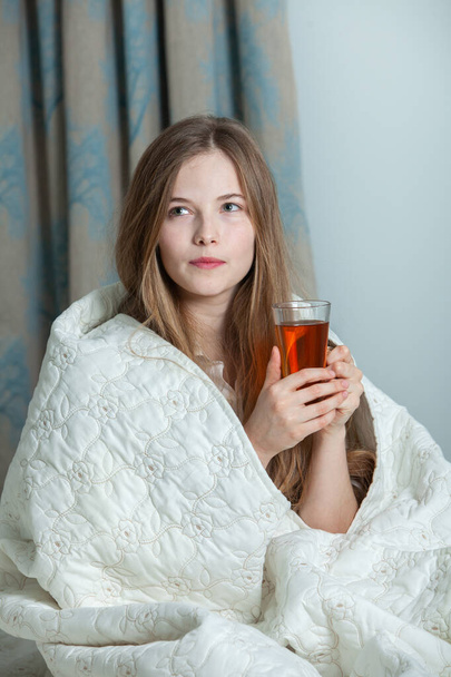 Young beautiful white woman awaking in light room. Relaxed woman lying in bed and drink tea. Good morning concept. Russian girl. - Foto, immagini