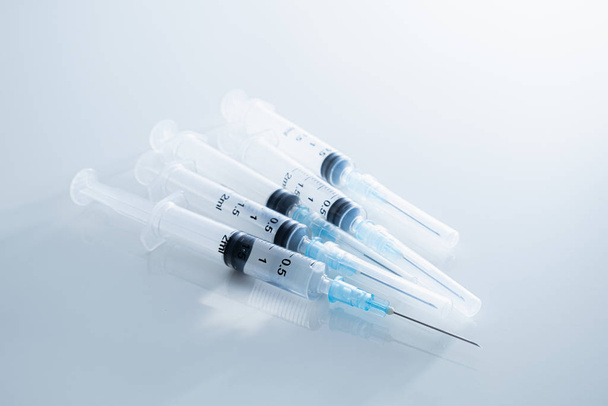 Syringes in clean medical background. Concept of injection drugs, medicine, vaccination or intravenous shots  - Zdjęcie, obraz