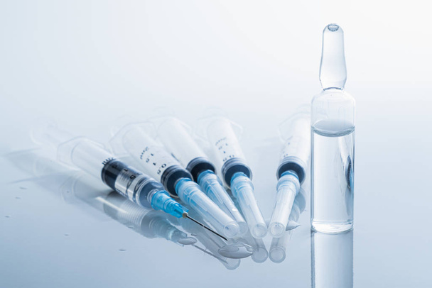 Syringes in clean medical background. Concept of injection drugs, medicine, vaccination or intravenous shots  - Zdjęcie, obraz