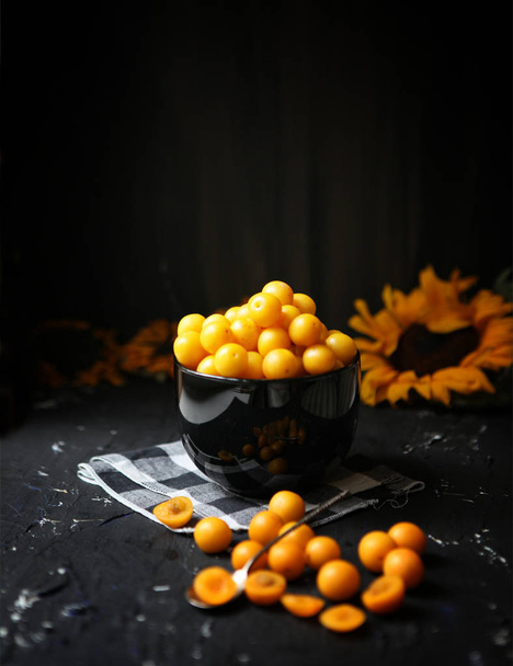 Žluté švestky s citronem a citrónem na černém pozadí. Ingredience na marmeládu. Fotka jídla. Žluté slunečnice, Podzimní koncepce, - Fotografie, Obrázek