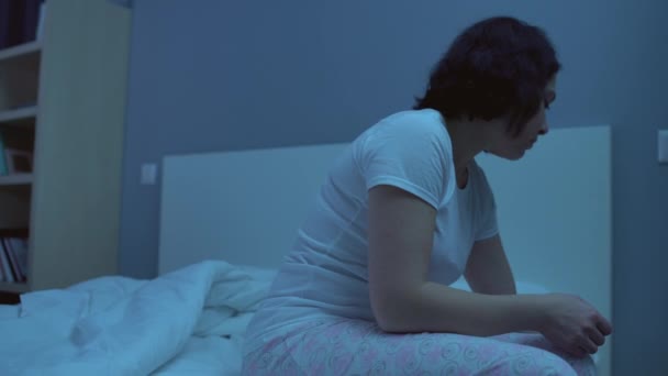 Depressed woman taking sedative pill before sleep sitting on bed alone, insomnia - Video