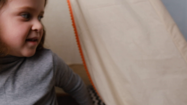Lähikuva onnellinen lapsi omistaa ja katselee kameran puhuminen videopuhelu vlog kommunikoida verkossa istuu teltassa lastenhuoneessa. Online viestintä käsite. Hidastus
 - Materiaali, video