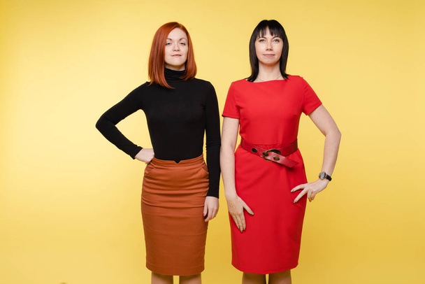zwei selbstbewusst lächelnde Geschäftsfrauen posieren mit Blick in die Kamera - Foto, Bild