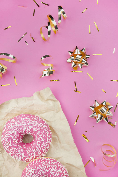 Donuts com cobertura rosa com confete dourado e arcos em um fundo rosa. Cor na moda e estilo. O apartamento estava deitado. Espaço de cópia A ideia de um blogueiro
. - Foto, Imagem