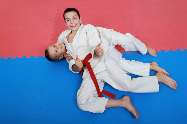 Dos jóvenes deportistas con un cinturón rojo y blanco muestran dedo super
 - Foto, imagen