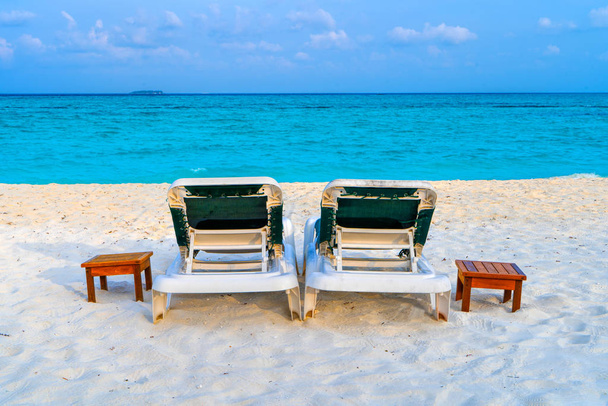 Maldivler 'de güzel bir tropik plajda şezlonglar. - Fotoğraf, Görsel