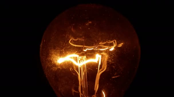 Villogó villanykörte / Valódi villanykörte bekapcsolása, ragyog és villogó fekete háttér - Felvétel, videó