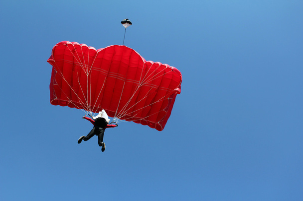 spadochroniarz z czerwony spadochron na błękitne niebo - Zdjęcie, obraz