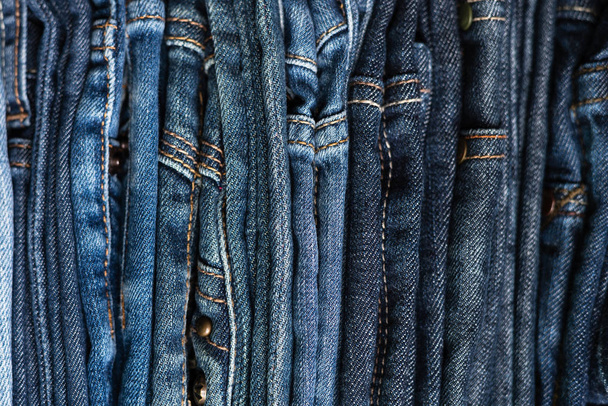 異なる色合いの青いジーンズのスタック。ジーンズの背景。接近中だソフトフォーカス - 写真・画像