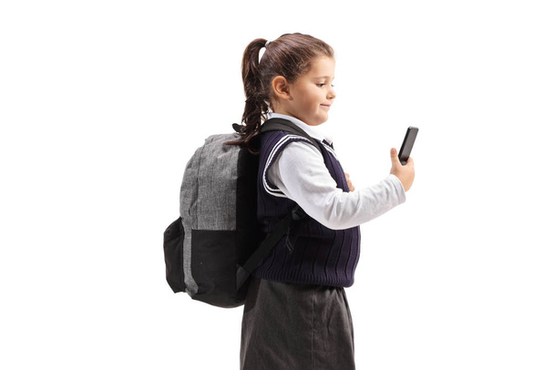 Schoolgirl in a uniform using a mobile phone  - Foto, Imagem