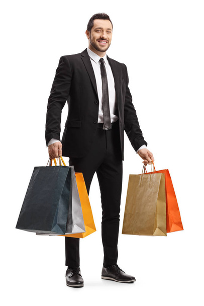 Businessman smiling and holding shopping bags - 写真・画像