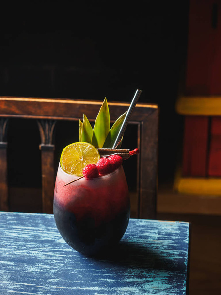 Red cocktail with raspberry lemon cinnamon and metal tube - Foto, Imagem