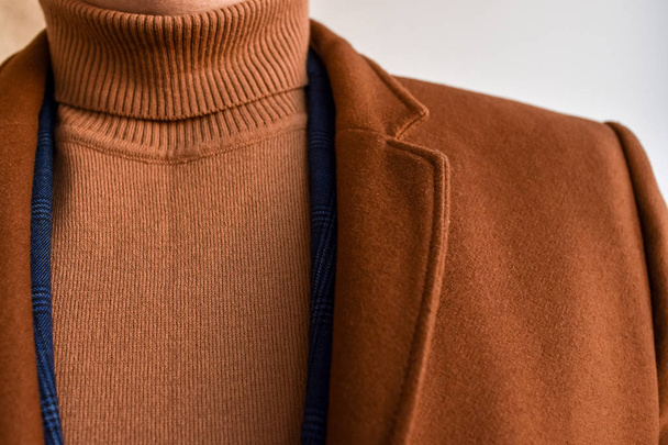 Zbliżenie modny męski brązowy płaszcz w połączeniu z brązowym modnym swetrem. Niski DOF.  - Zdjęcie, obraz