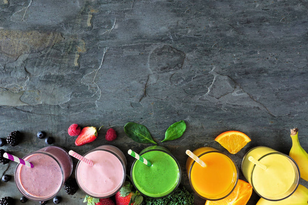 Assorted healthy fruit smoothies. Top view bottom border against a dark background. Copy space. - Photo, Image