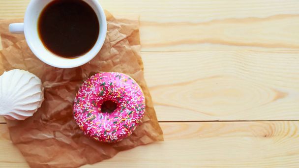 White zefir, coffee cup and pink donut on wooden table, top view. Copy space for the text - Фото, изображение