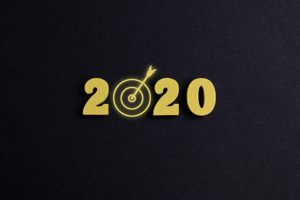 Концепция достижения целей на 2020 год. Деревянные фигуры на черном фоне. Вид сверху
. - Фото, изображение