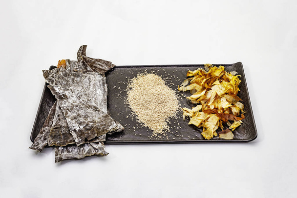 Sada tradičních japonských ingrediencí pro vaření základních dashi vývarů. Řasy kombu, katsuobushi a hotové suché granule. Izolováno na bílém pozadí - Fotografie, Obrázek