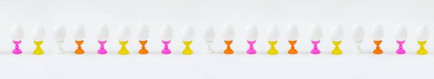 White eggs on wooden coasters forms white background. Getting ready for the Easter holiday. - 写真・画像