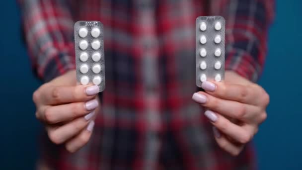 mujer que presenta una mano de píldoras envueltas en papel de aluminio
 - Metraje, vídeo