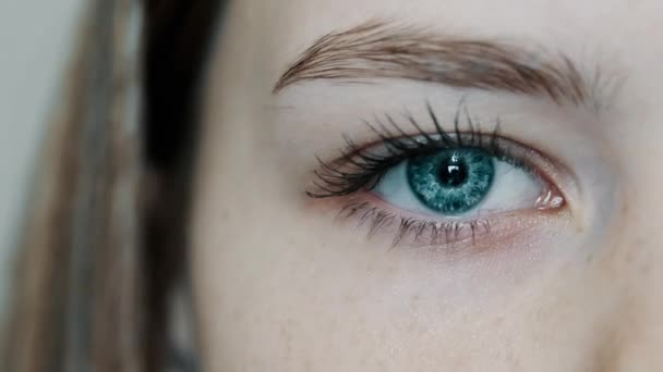 Menina de olhos azuis abre seu belo olho e olha para a câmera
 - Filmagem, Vídeo