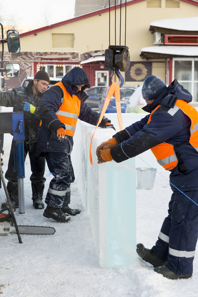 Trabajadores en ropa de trabajo de invierno instalando paneles de hielo
 - Foto, Imagen