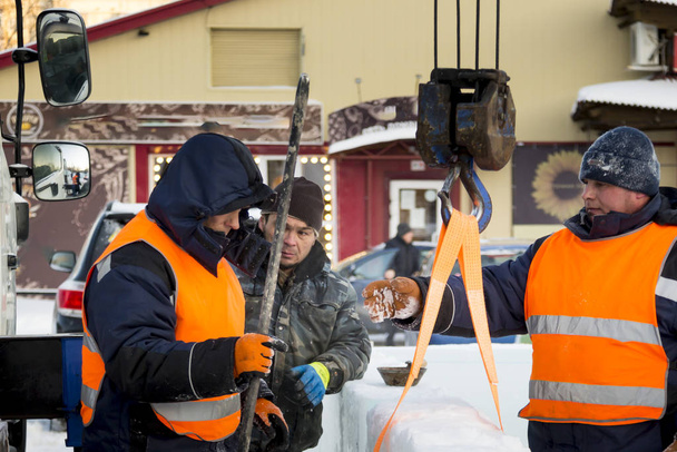 Talvipukuiset työntekijät asentamassa jääpaneeleita
 - Valokuva, kuva