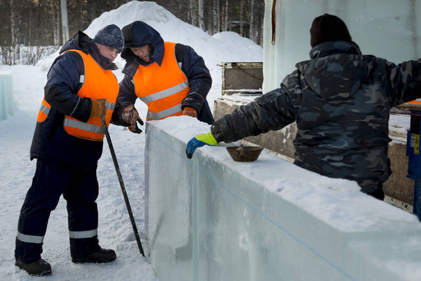 Werknemers in de winter werkkleding installeren van ijs panelen - Foto, afbeelding