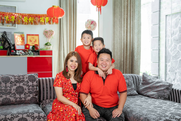 Азиатская семья с двумя сыновьями, улыбаясь, глядя в камеру
 - Фото, изображение