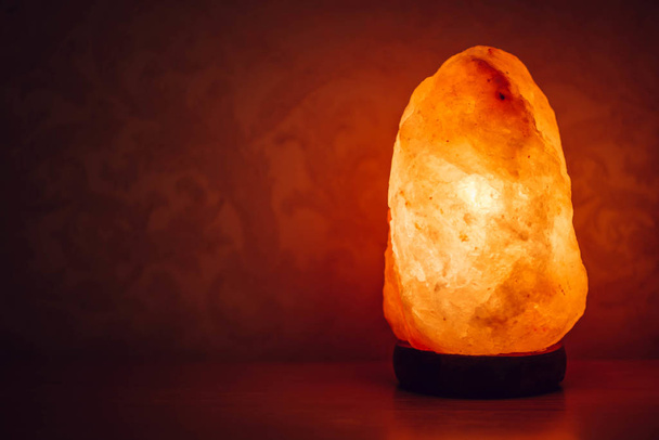 Salt lamp on the table in the room glows in the night - Photo, Image