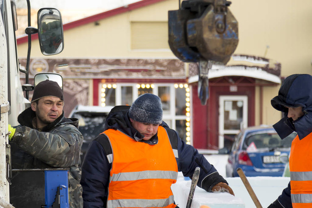 Téli munkaruhában dolgozók jégtáblákat szerelnek fel - Fotó, kép