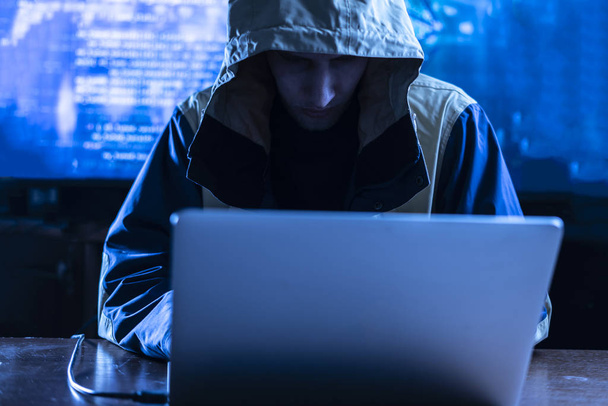 ανώνυμη hacker φρενάροντας τα προσωπικά δεδομένα στο γραφείο του, σκούρο μπλε, βαθύ web - Φωτογραφία, εικόνα