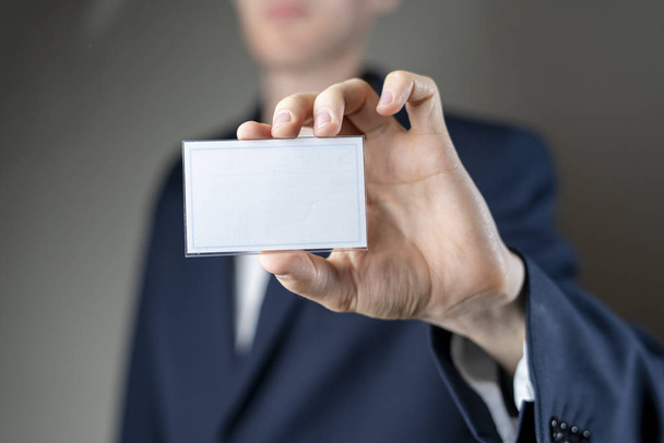 бизнесмен, держащий пустой значок с макетом копировального пространства, авторизацией и идентификацией
 - Фото, изображение
