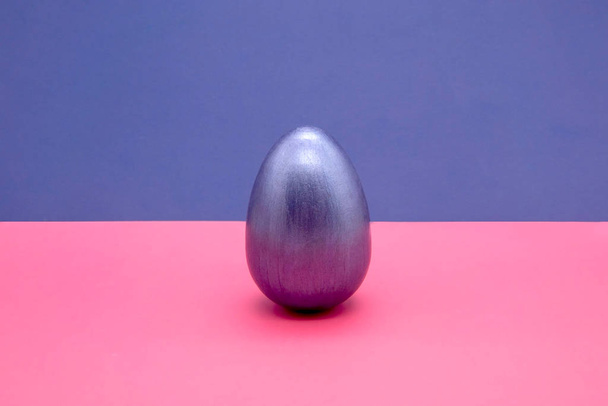 one blue Easter eggs on blue and pink background - Fotoğraf, Görsel