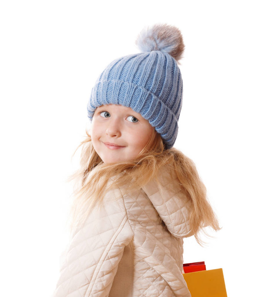 Little girl in blue knitted cap with fur  pompon and beige jacke - Zdjęcie, obraz