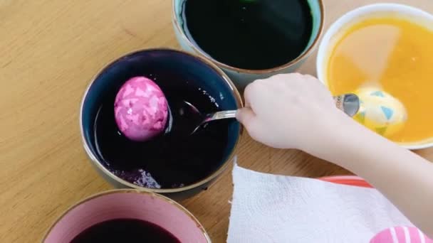 Close up of kid hands coloring easter eggs with egg dye. - Felvétel, videó