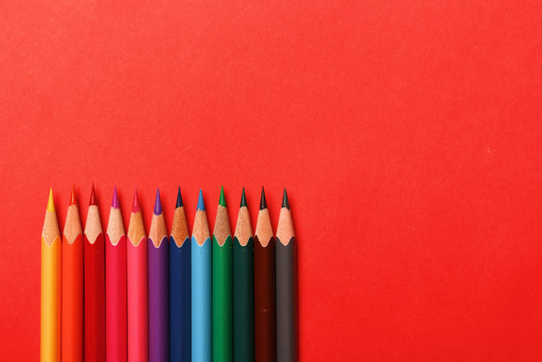 Multicolored pencils on a red background - Foto, afbeelding
