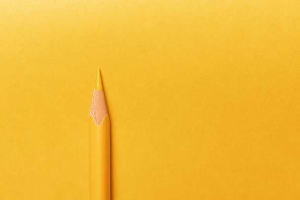 Yellow pencil on yellow background - Foto, afbeelding