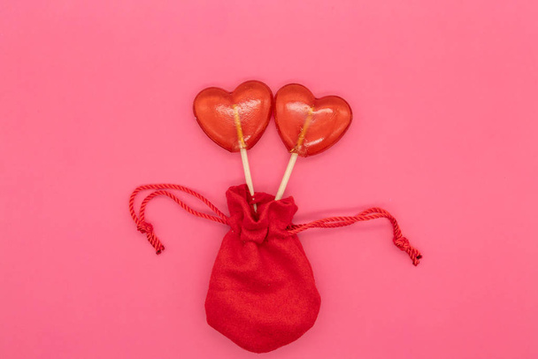 Δύο γλειφιτζούρια. Κόκκινες καρδιές. Καραμέλα. Έννοια της αγάπης. Ημέρα του Αγίου Βαλεντίνου. - Φωτογραφία, εικόνα