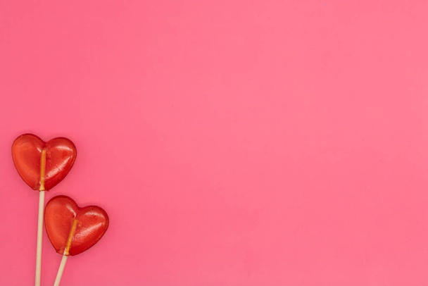 Два леденца. Красные сердца. Конфеты. Концепция любви. День Святого Валентина
. - Фото, изображение