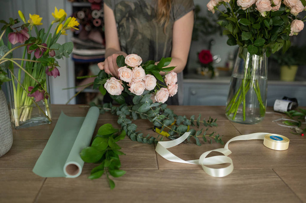 Florist girl makes a bouquet. Flower shop. - Fotó, kép