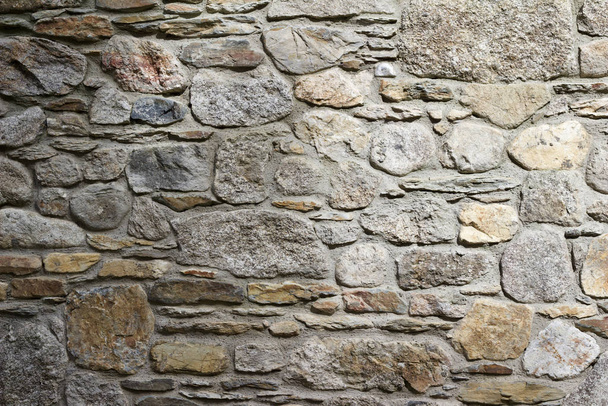 Fondo de textura de pared de piedra gris antiguo, con ladrillos expiatorios en diferentes formas y tamaños
 - Foto, imagen