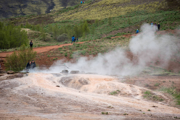 Tourists visiting Strokkur geyser in Iceland - Фото, изображение