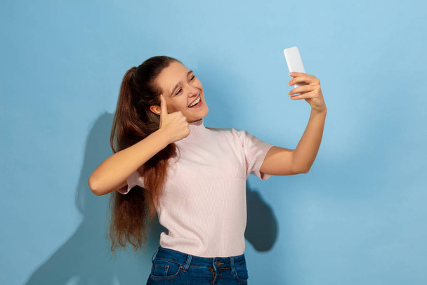 Caucasian teen girl portrait isolated on blue studio background - Foto, immagini