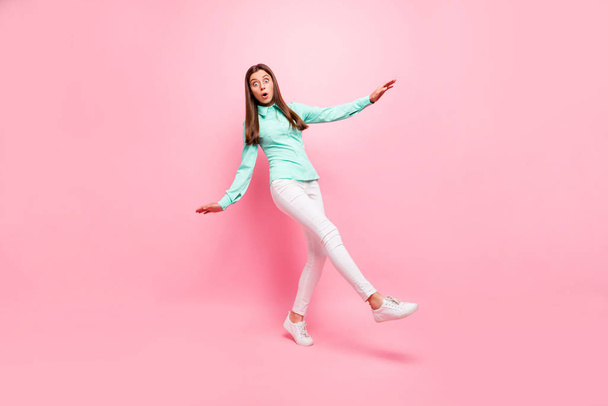 Full body photo of funny lady walking down street slippery ground eyes full fear falling down wear specs turquoise shirt white trousers isolated pink color background - 写真・画像