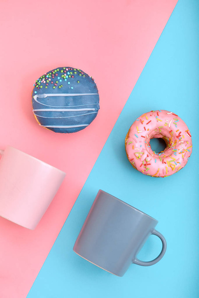 Sweet donuts pink and blue with a mug of coffee. Blue and pink background, game of colors, color conflict. Mock up for design. Copy space. - Foto, Imagen
