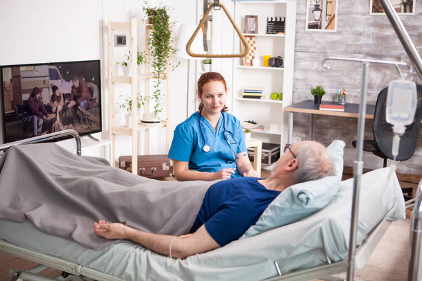 Žena lékař se stetoskopem sdílení pohodlí pro starého muže - Fotografie, Obrázek